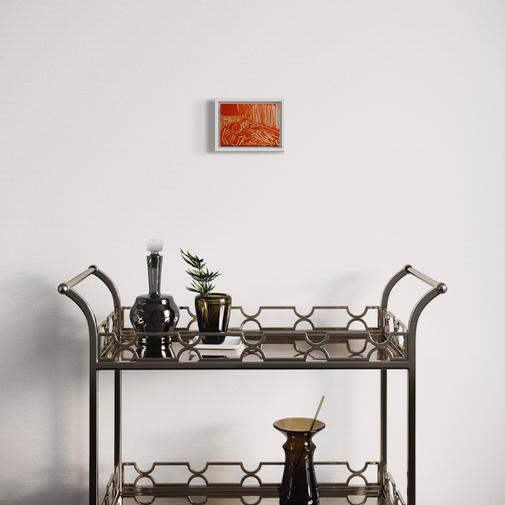 Orange Living Room VI by Chelsie Sunde: A vibrant monotype print in orange hues mounted above a decorative bar cart, featuring abstract geometric patterns and architectural elements. The 6x8 inch artwork creates a striking focal point against a white wall, complementing the metal serving cart's geometric design and home decor elements below.