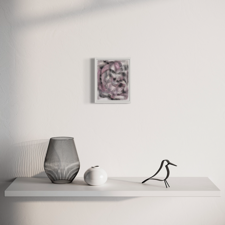 The artwork 'Soul Away (3)' by Diana Naccarato features abstract swirls in pink and gray tones created with acrylic and clay on paper, displayed in a white frame. Shown in a minimalist setting with decorative objects on a white shelf, including a wire mesh vase, ceramic piece, and black bird ornament. 8x6 inches framed artwork by Diana Naccarato.