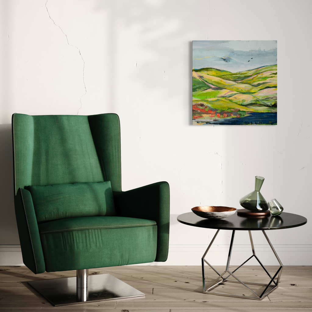 The artwork 'Hills and Valleys #3' by Nicki Adani features undulating green and yellow hills beneath a misty blue sky, rendered in expressive brushstrokes on wood panel. The abstract landscape composition captures rolling terrain with touches of coral and earth tones, creating a dynamic mixed media interpretation of natural topography by artist Nicki Adani.