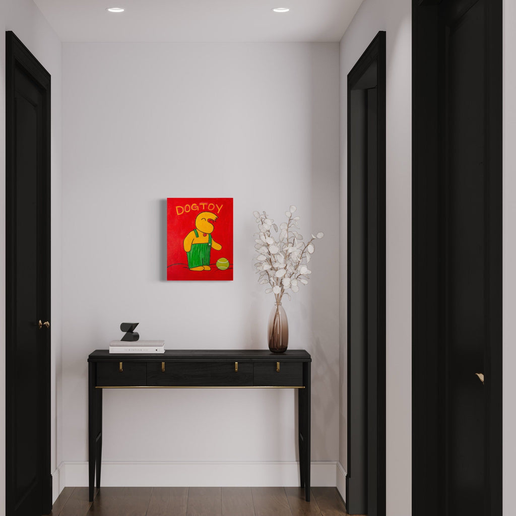 The artwork 'Dogtoy' by Andrew Psomas features a vibrant red background with a stylized yellow figure playing with a green ball. The minimalist composition, created with acrylic paint and oil-based markers on canvas, displays bold graphic design elements reminiscent of retro poster art. The 20x16 inch canvas showcases a playful, contemporary interpretation of canine entertainment. - Andrew Psomas