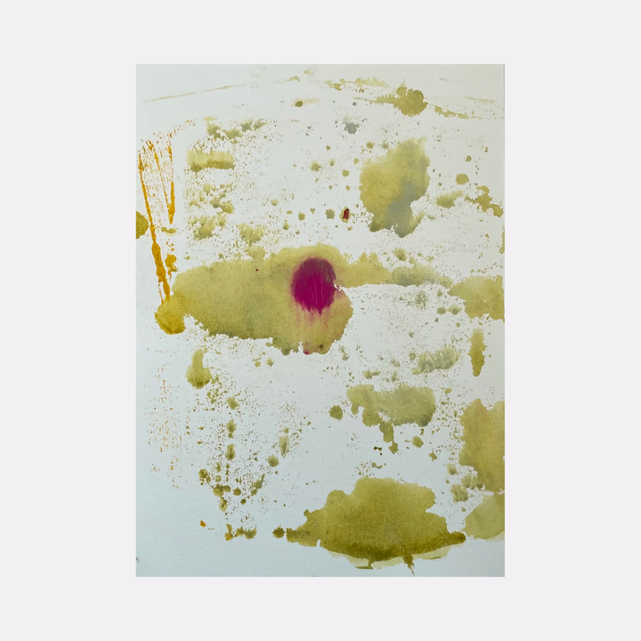 The artwork 'Re.lease #7' by Dina AZ Salem features abstract acrylic splatters on white paper, with organic olive-green pools and splashes scattered across the surface, punctuated by a striking magenta spot in the center. The composition creates a floating, ethereal effect with varying paint densities and watercolor-like textures.