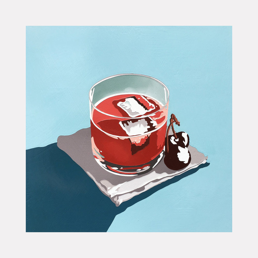 The artwork 'Cherry Cocktail' by Lori Larusso depicts a stylized red cocktail in a clear lowball glass with floating ice cubes, accompanied by a dark maraschino cherry on a light gray napkin, set against a serene blue background. The piece features clean lines and bold color blocks in acrylic and enamel on wood panel.