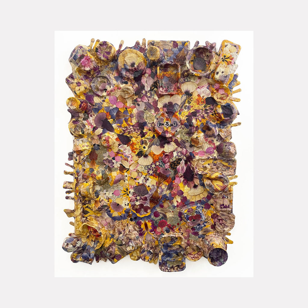 The artwork 'Defloree History #4 Maturity' by Valerie Hallier features a textured collage of dried flower petals arranged in circular patterns. Rich golden yellows blend with deep purples and burgundies, creating a mosaic-like composition. The mixed media piece incorporates plaster cloth and recycled materials on a wood panel, showcasing organic forms and layered dimensional elements.