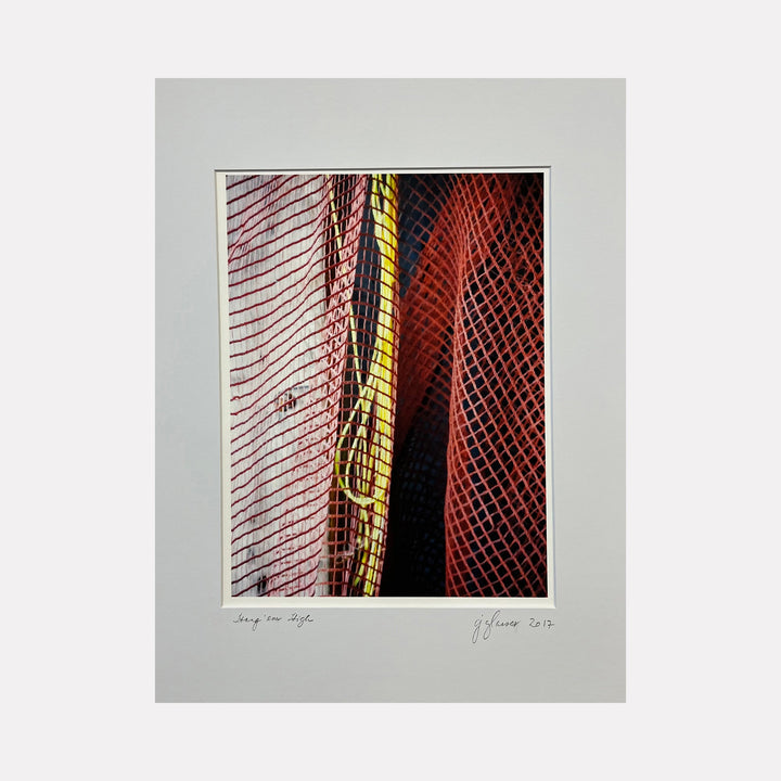 The artwork 'Hang 'em High' by Cora Jane Glasser features dramatic intersecting diagonal lines in rich burgundy, vibrant yellow, and deep black. Abstract patterns include crosshatched mesh, parallel stripes, and a central golden column, creating dynamic tension and depth on velvet archival paper.