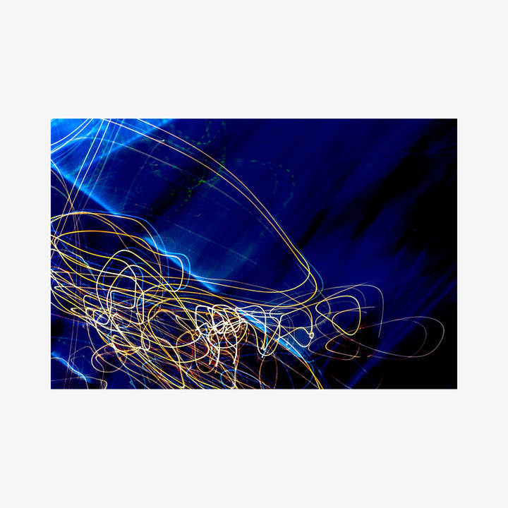 The artwork 'Particle Physics 30' by Chunbum Park features dynamic light trails against a deep blue background, resembling subatomic particle movements in space. Golden and white luminous streaks create intricate spiral patterns, evoking quantum physics visualization. This abstract giclee print captures energy in motion through vibrant colors and fluid lines. - By Chunbum Park