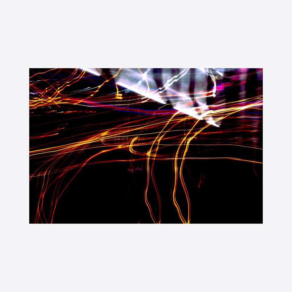 The artwork 'Particle Physics 33' by Chunbum Park features dynamic light trails against a dark background, with vibrant orange and red streaks sweeping across the frame, complemented by ethereal white illuminations at the top. The abstract composition captures motion and energy through long-exposure photography techniques. By Chunbum Park.