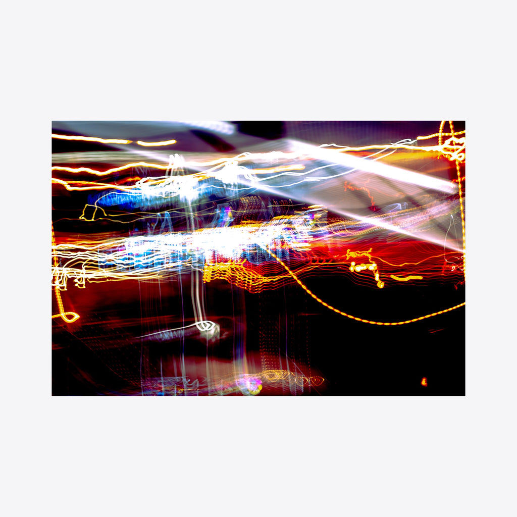 The artwork 'Particle Physics 34' by Chunbum Park features dynamic light trails creating abstract patterns against a dark background. Vibrant streaks of red, white, blue, and golden light interweave across the composition, suggesting motion and energy. The long-exposure photography technique captures luminous paths resembling subatomic particle movements in a quantum field. Print dimensions 10x15 inches. By Chunbum Park.
