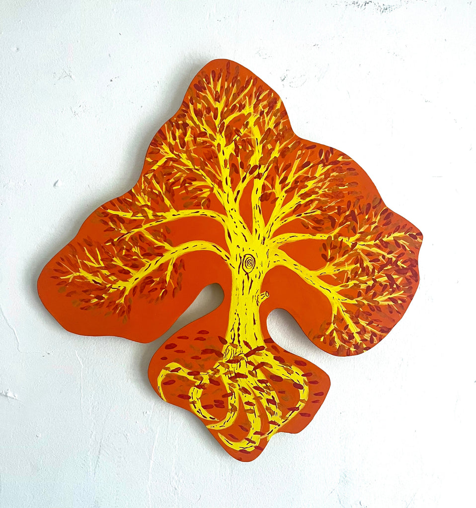 The artwork 'Summer Tree' features a vibrant tree silhouette painted in luminous yellow against a bold orange puzzle-piece shaped background. Intricate branches spread outward in a delicate pattern, while twisted roots curl beneath. Created in matte acrylic on wood with precise detail and striking warm color contrast. By Sunny Chapman.