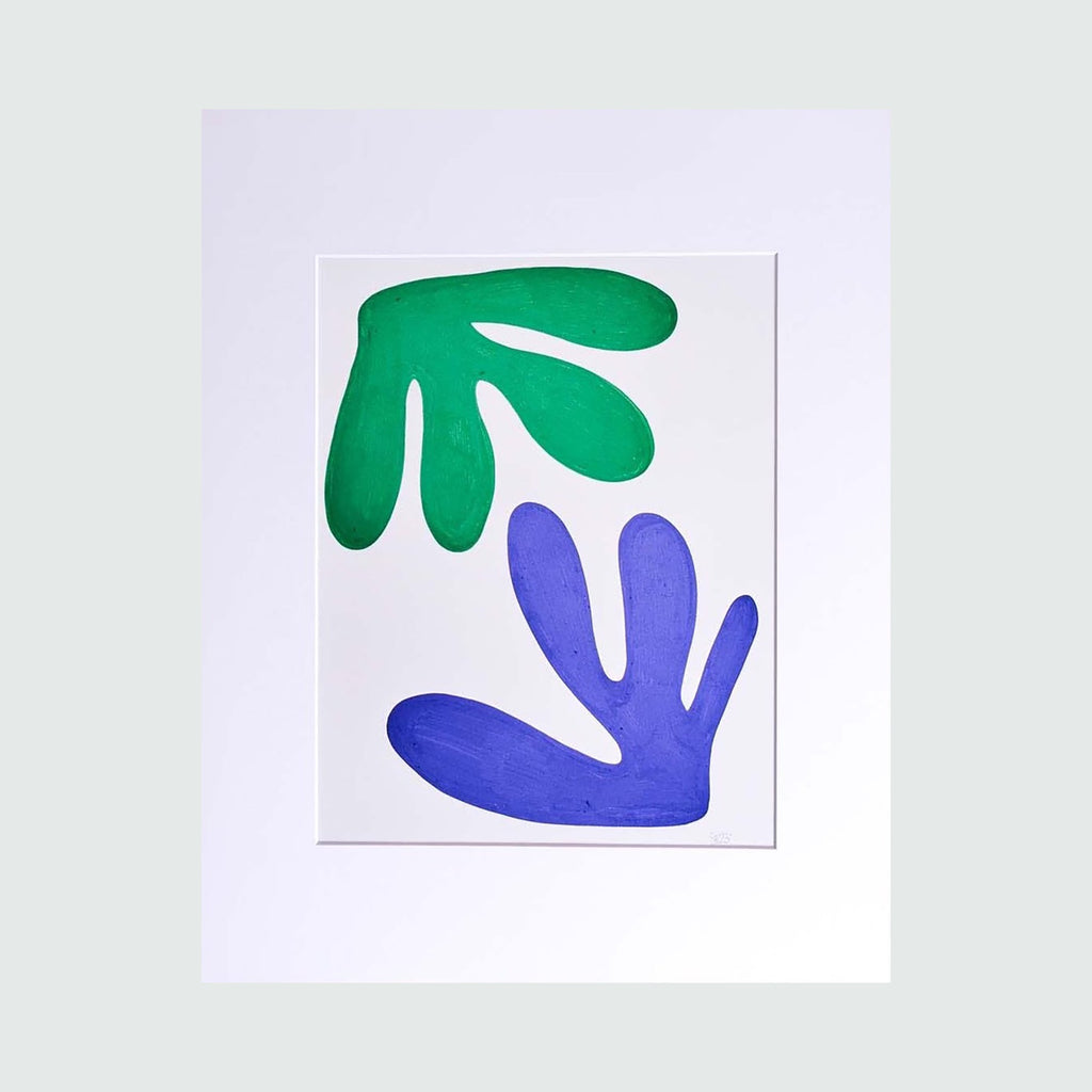 The Morning Meditation Series 5 by Shadia Sabagh features a minimalist freehand drawing with two abstract leaf-like shapes - one in vibrant emerald green positioned at the top and another in royal blue below, both set against a crisp white background. The organic forms create a harmonious balance, reminiscent of Matisse's cut-out style artwork. Limited edition print, 20x16 inches.