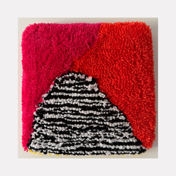 The artwork 'Storm King' by Ana Maria Farina features a striking triangular composition with textured upcycled fibers on linen. A dramatic black and white striped mountain-like form rises against a vibrant background split between deep magenta and bright coral red. The 9x9 inch piece showcases dense, tactile fiber work creating a dynamic contrast of colors and patterns.