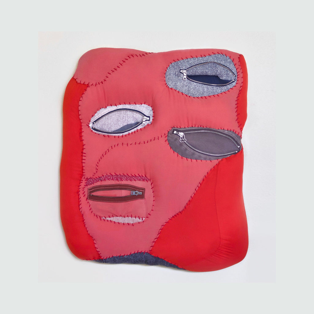 The artwork "For Safekeeping" by Hanna Washburn features a vibrant red textile composition with four oval-shaped openings revealing metallic zippers. The piece combines coral and scarlet recycled fabrics meticulously stitched together, creating an organic, wave-like form. Each zipper pocket is framed by gray fabric patches with visible running stitch details, mounted on a wooden frame.