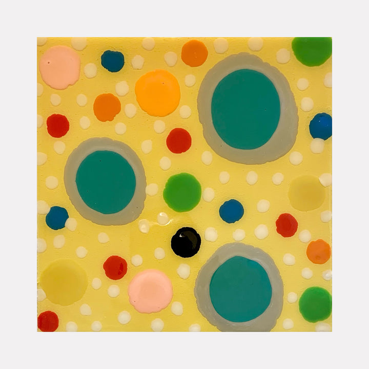 The artwork 'Piece of Cake 912' by Lori Kirkbride features vibrant polka dots in varying sizes on a soft yellow background. Three large turquoise circles with gray borders dominate the composition, surrounded by smaller dots in red, orange, pink, green, and navy blue. The acrylic and resin create a playful, modern abstract pattern with a glossy finish.