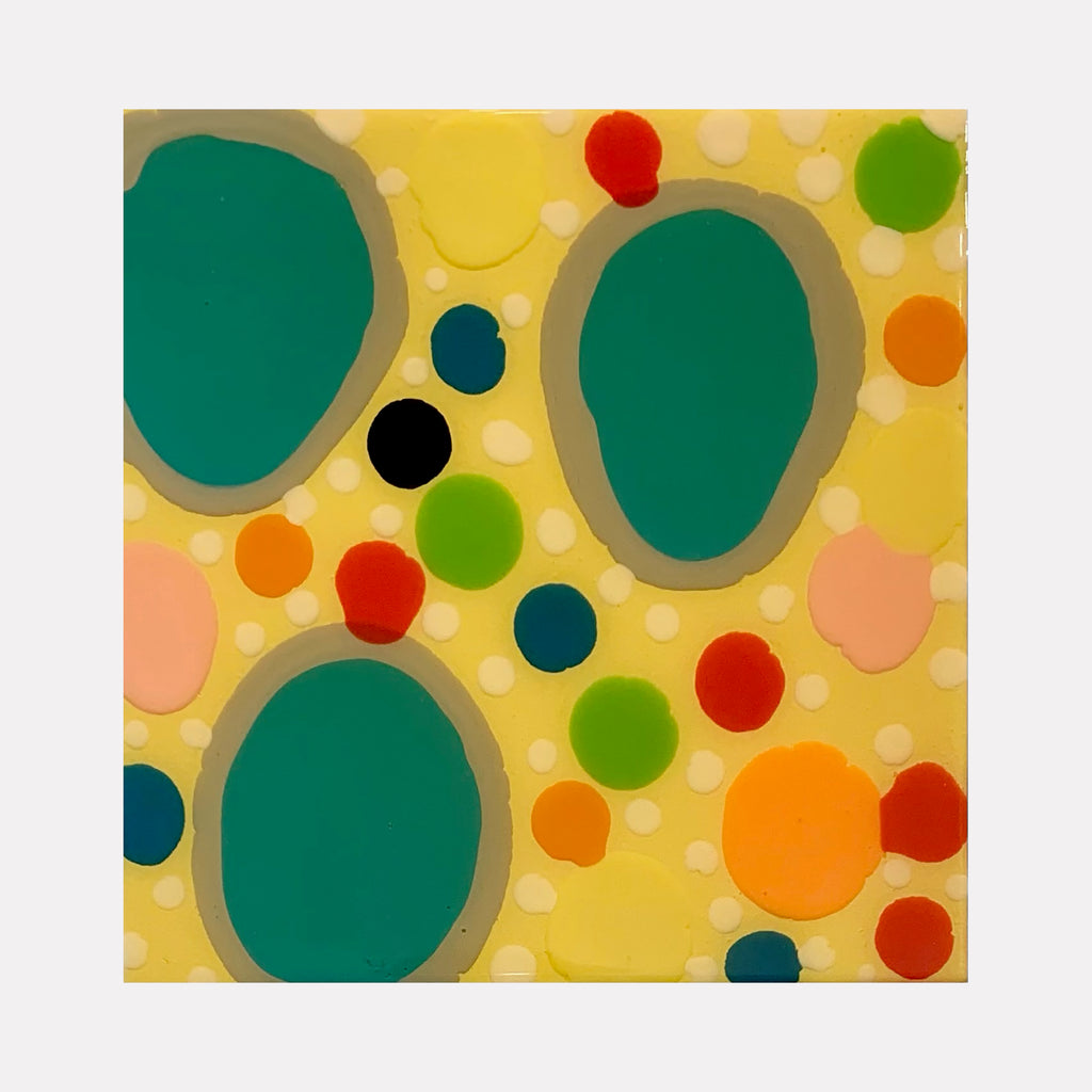The artwork 'Piece of Cake 946' features vibrant organic shapes on a sunny yellow background. Large teal-green pools dominate the composition, surrounded by playful dots in orange, red, and lime green. The abstract pattern creates a dynamic, bubbly effect using acrylic polymer and resin on panel. By Lori Kirkbride.