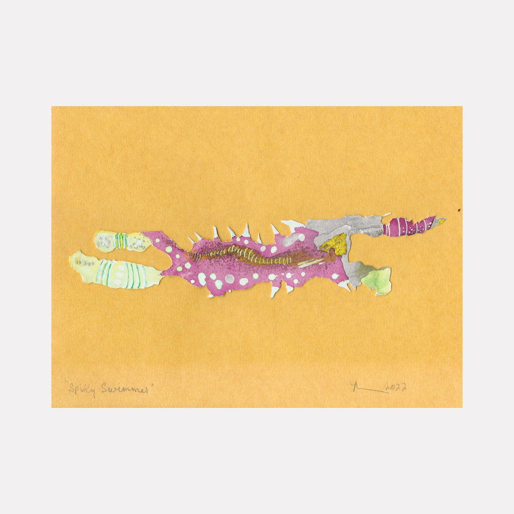 The artwork 'Spiky Swimmer' by Linda Lee Nicholas features a whimsical aquatic creature rendered in ink cutout technique. The abstract fish-like form combines mint green, purple, and silver tones with delicate white spikes along its body, set against a warm golden yellow background. The playful composition measures 8x11 inches and showcases a unique blend of organic shapes and textural elements.