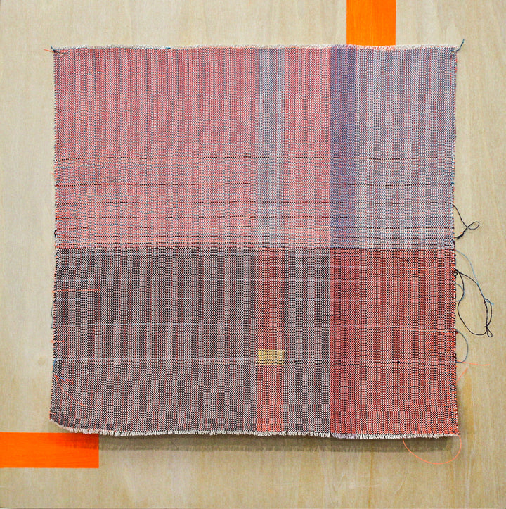 The artwork 'something about the weather 2' by Molly Koehn features a handwoven geometric composition of intersecting lines in muted pink and gray tones. The textural piece combines stainless steel, linen, silk, and nylon, creating a grid-like pattern with subtle color transitions. Orange accents frame the textile work, contrasting against the natural wood background.